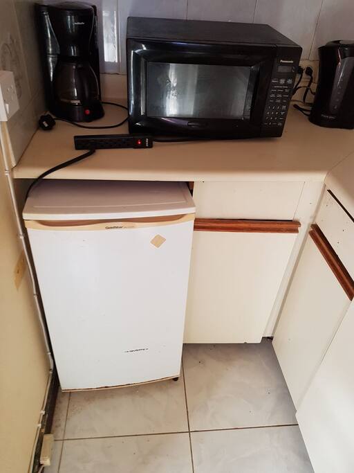 Coffee maker, microwave, kettle and small fridge.