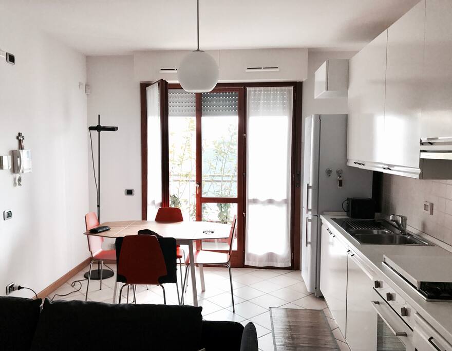 Kitchen with a balcony, fully equipped cooking space and dinner table