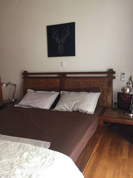 Room 1: Comfortable double wooden bed.