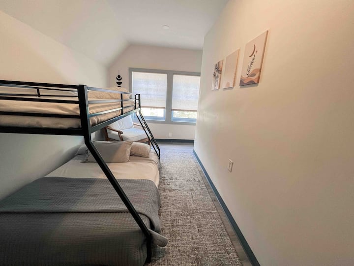 تحتوي غرفة النوم الأولى على سرير مزدوج فوق سرير بطابقين كاملين وكرسي بذراعين. 