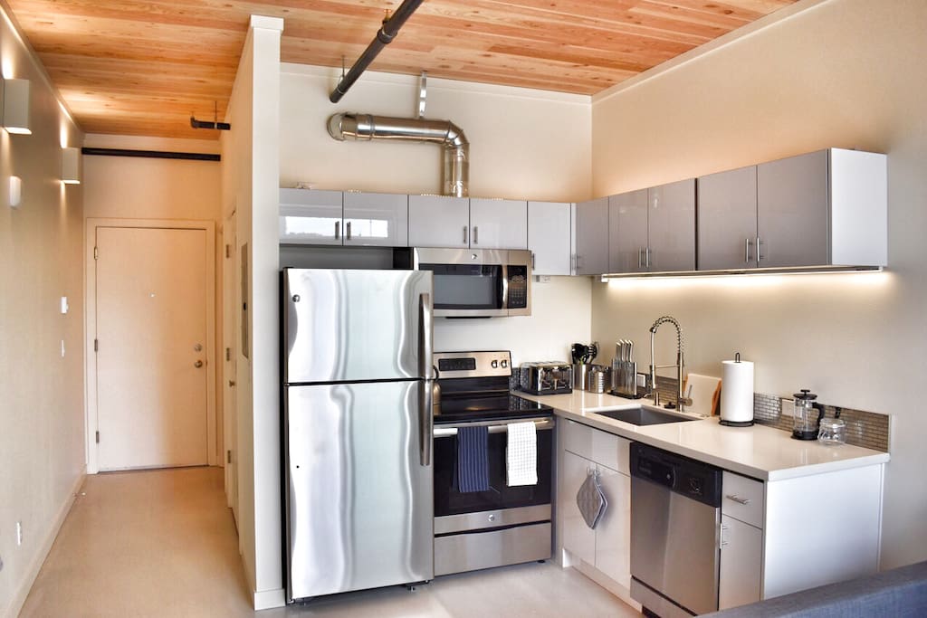 Chef's kitchen with Brand new stainless steel appliances, quartz countertops and concrete floors.
