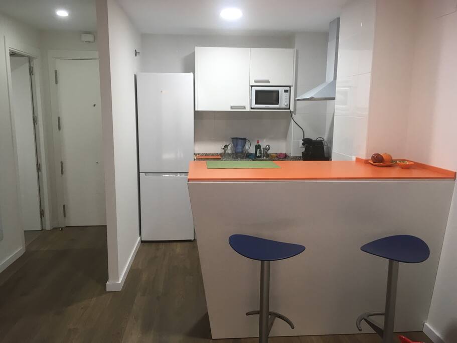 Barra americana de diseño con encimera de Corian naranja. Delicado ante abrasión y rayas.