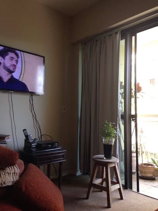 Sala com sofá e TV é vista varanda