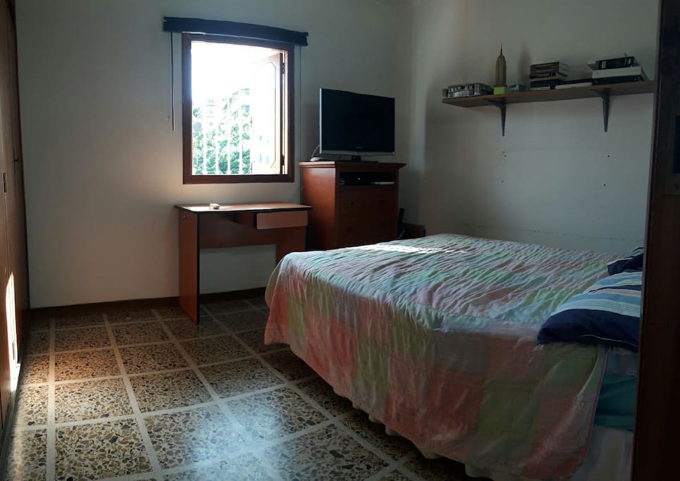 habitación con cama matrimonial, TV por cable, escritorio, aire acondicionado y baño privado