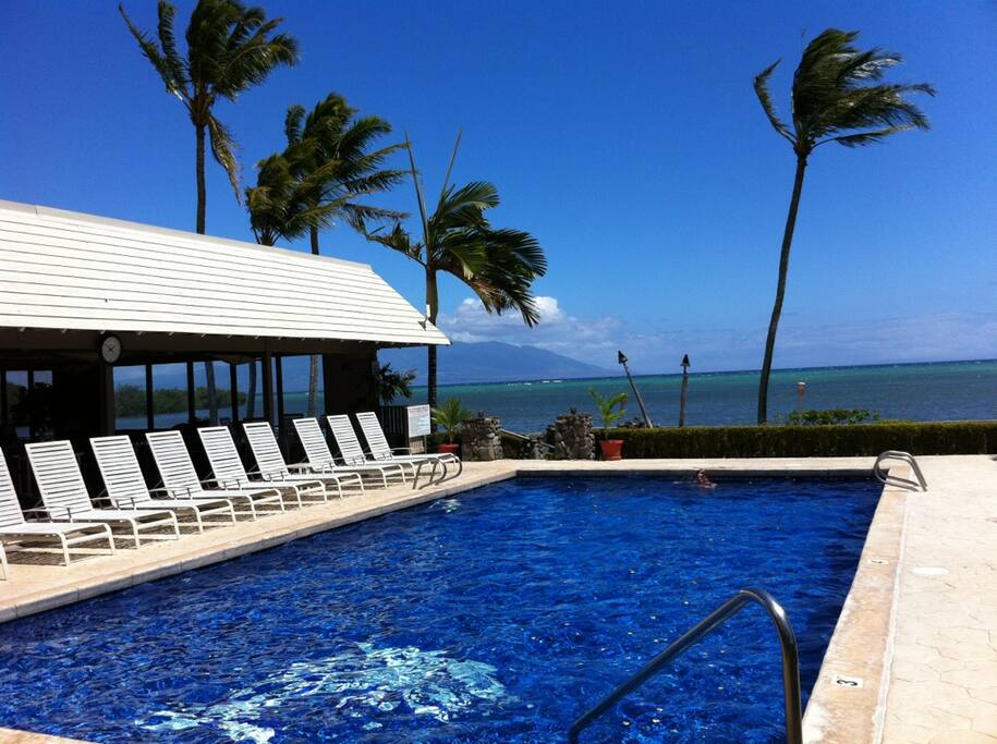 Wavecrest pool with Maui in background and large covered clubhouse on left with large glass picture windows at waters edge