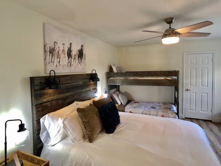 ห้องนอนผู้เข้าพักที่มีห้องน้ำในตัวและเตียงสองชั้นคู่รวมถึงแพ็คของและเล่น