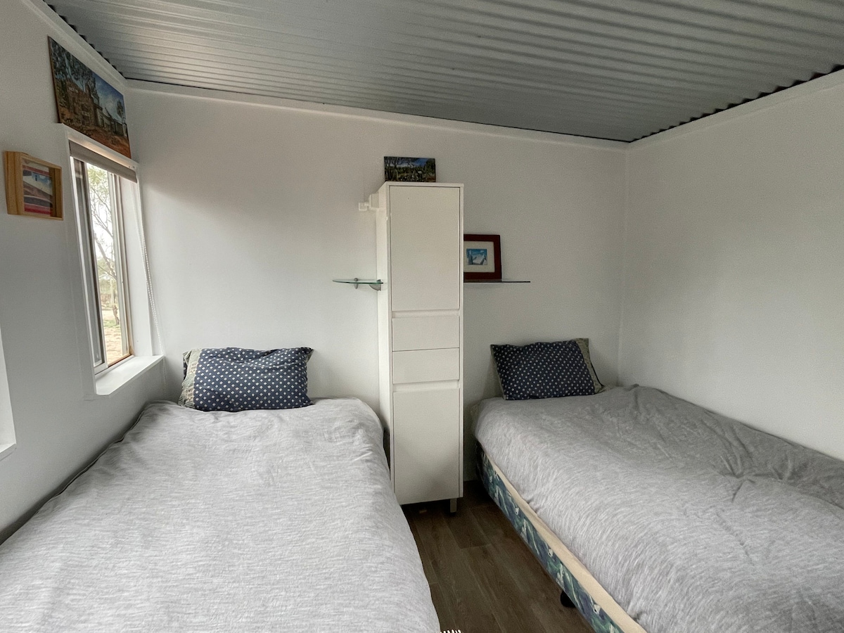 Two single beds with organic cotton linen and towels.