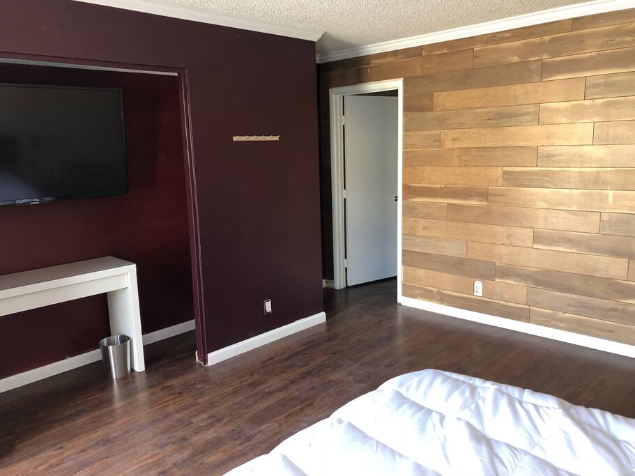 Wood paneling, 55' Smart TV, work desk, coat rack.