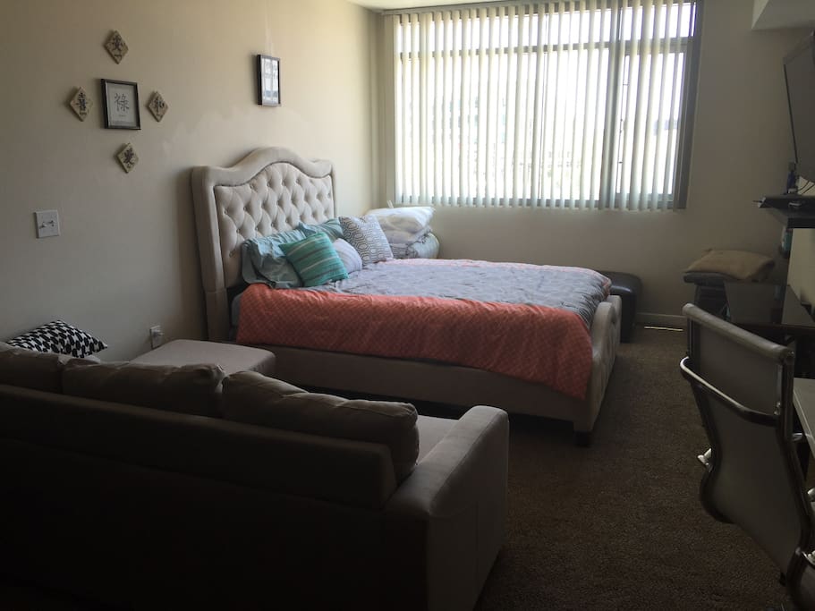 The main living area of the studio include a plush queen sized bed, sofa with chaise and a desk & chair. There's a 48" TV and PS4 to enjoy some gaming, DVDs & BluRay discs. Additional bedding is also located in the corner.