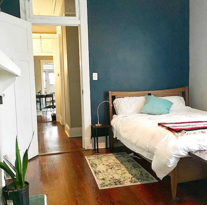 In typical shotgun homes you have to walk through one room to get to the other. Mine is no different, but I didn’t want it to feel like separate rooms. There had to be a flow so I used all the same colors throughout the house. Keeping the Mid-Century style I bought a vintage bed frame and converted it to a sleigh bed. I built the bench at the end of the bed and side table out of 100 year old recycled wood from the bayou and even made my own wood stain out of steel wool soaked in distilled white vinegar. It turned out so well.