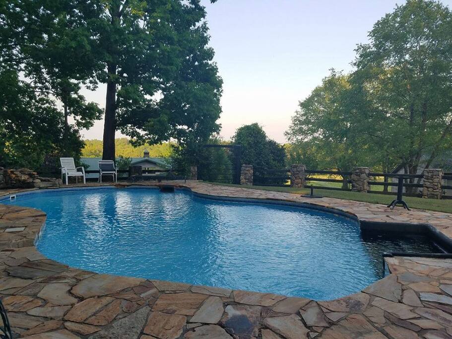 In a picturesque remote setting (beside the cottage) overlooking the lower barn, pastures and woodlands... This stone decked in-ground pool boasts a waterfall, spacious outdoor seating and peaceful serenity.