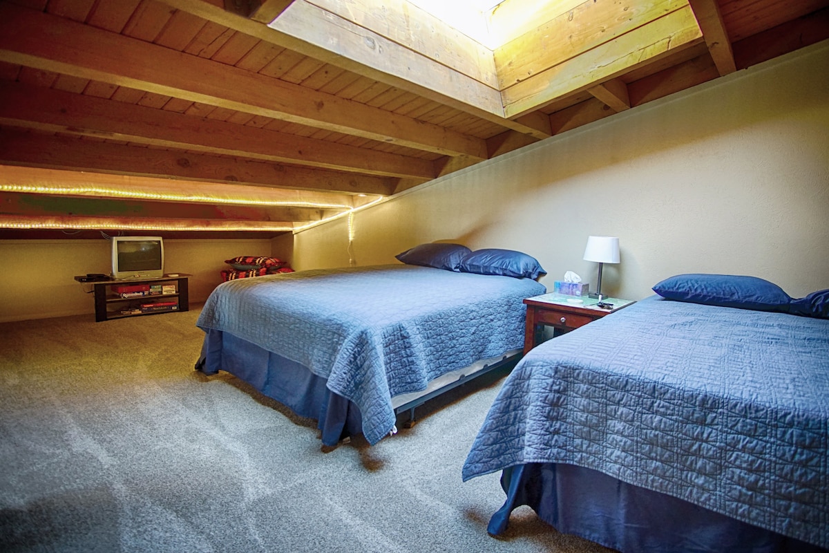 Hviezdny pohľad v noci cez nebeské svetlo, keď ležíte na jednej z dvoch manželských postelí v podkroví. 