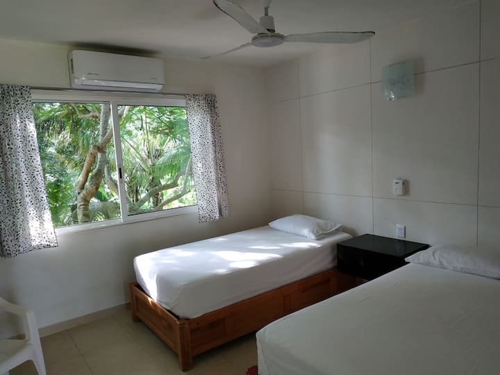 Habitación planta alta con una cama matrimonial y una individual, baño completo y con clima.