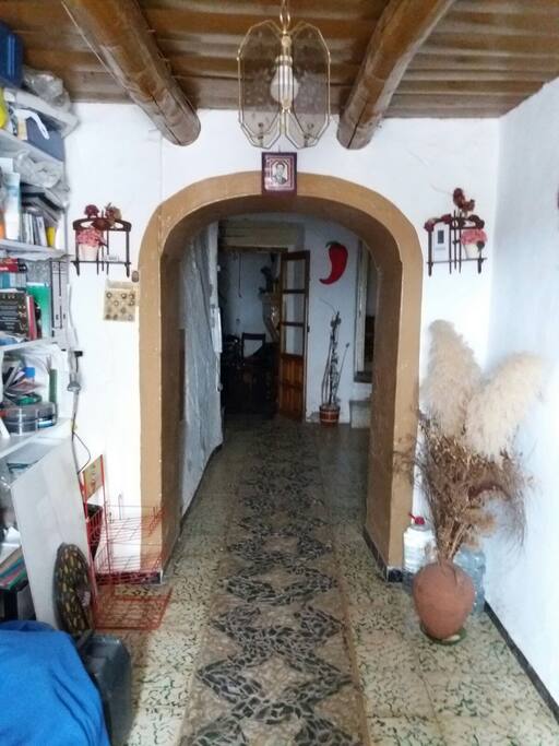 Entrada de la casa con arco y suelo empedrado
