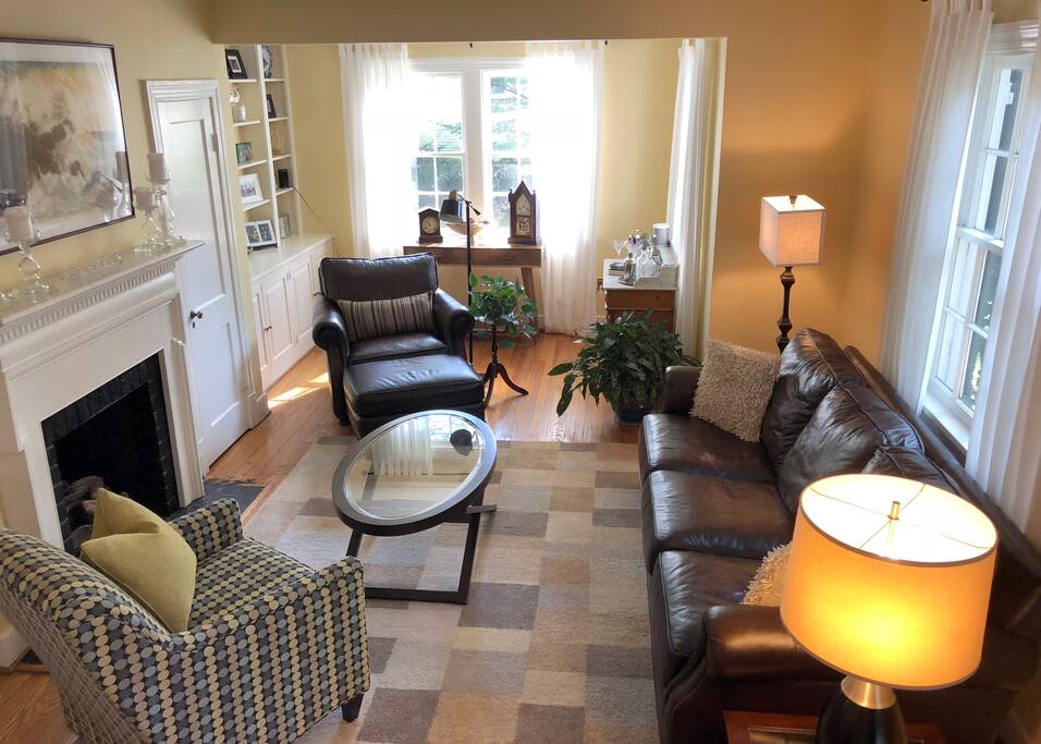 Comfortable living room with leather couch and chair/ottoman.