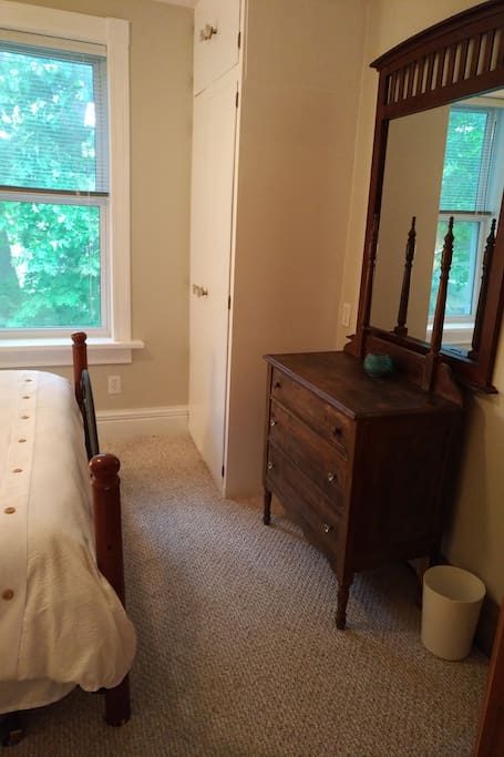 Queen bedroom with window and antique dresser