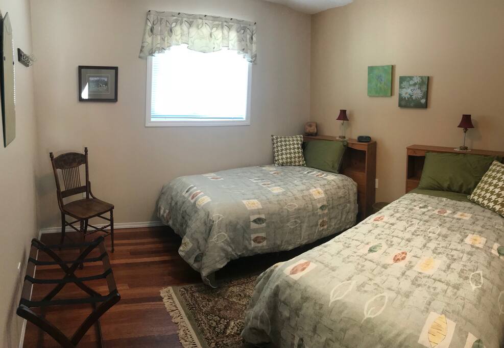 Aspen Room with two single beds, shared bathroom, and access to the living room, dining room, and south facing deck.