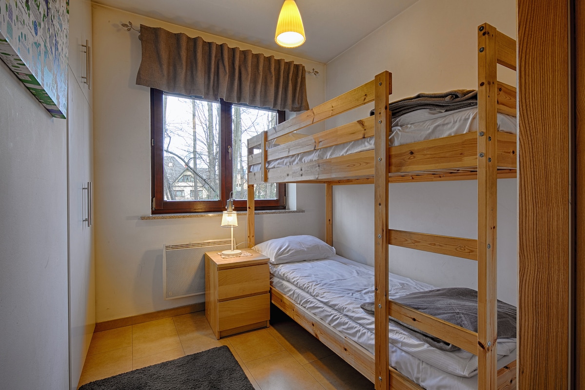 ห้องนอนที่มีเตียงสองชั้นเหมาะสำหรับทั้งผู้ใหญ่และเด็ก ด้านซ้ายมีตู้เสื้อผ้าขนาดใหญ่ ห้องนอนมีพรมนุ่มและแสงสว่าง