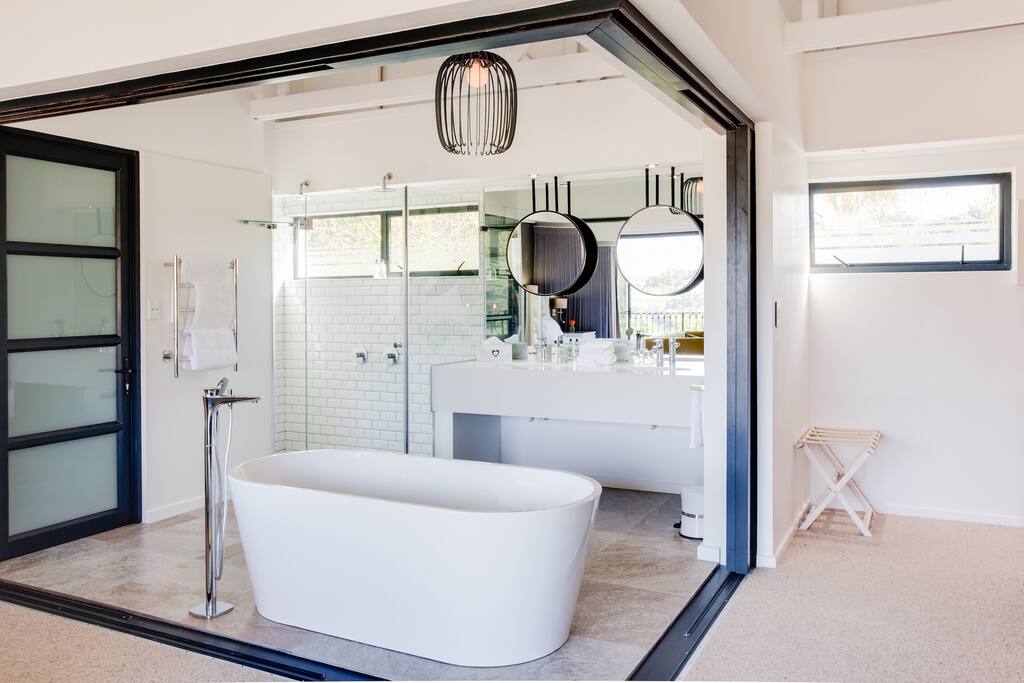 Bah tub in front of the fireplace and 2 head shower.