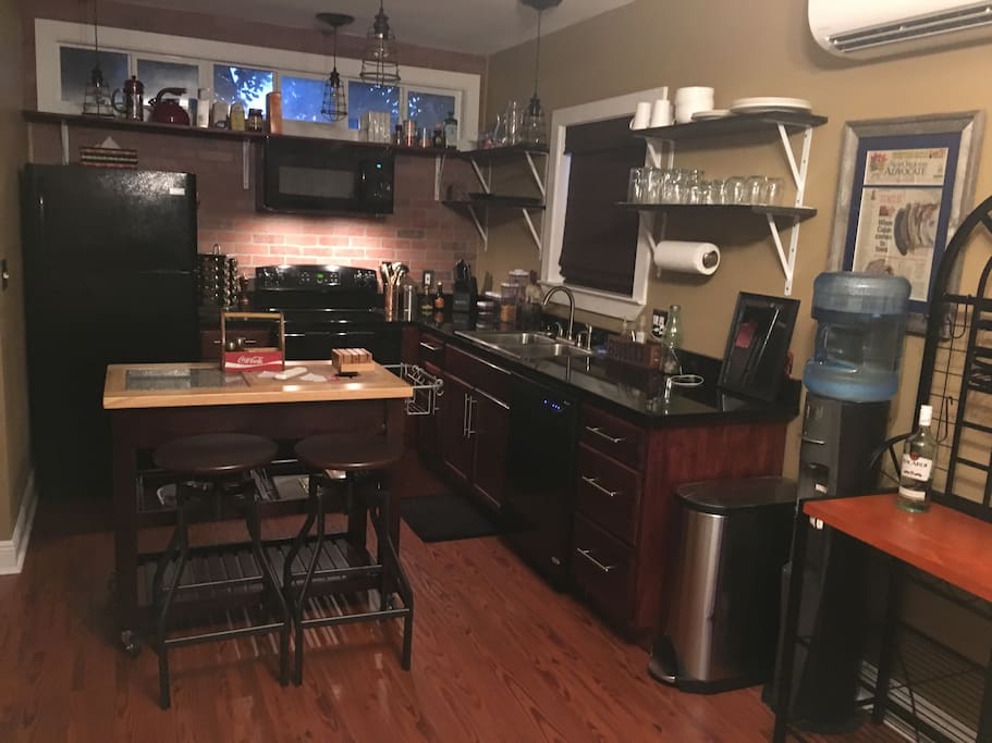 Kitchen with electric stove and dishwasher. Kentwood water machine and fridge w/ice-maker. (View from living room area)