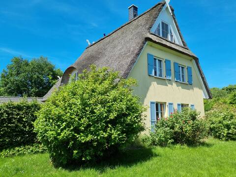 Thatched-roof house with large garden near the beach
