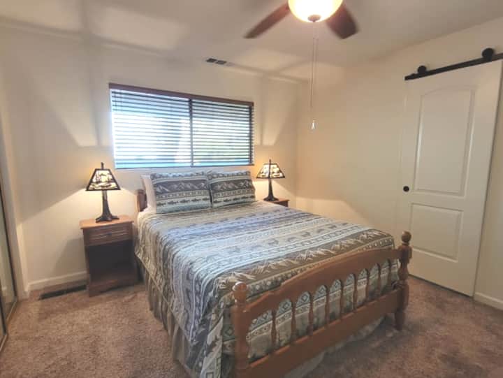 Dormitorio principal en el piso inferior con una cama tamaño queen y un baño completo adjunto.