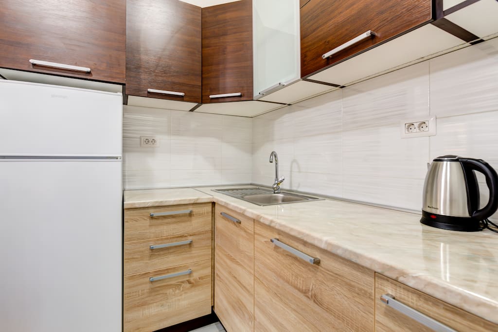 The kitchen is modernly equipped and includes a cooker, a cooker hood, a large fridge with a freezer.