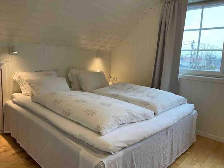 Soveværelse 1 på anden sal med 180 cm dobbeltseng og lyse gardiner