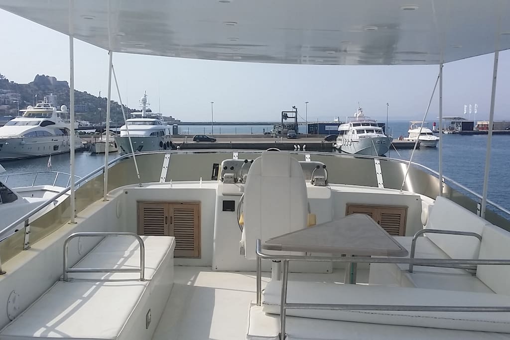 Covered upper deck/fly-bridge with cushioned seating and table area