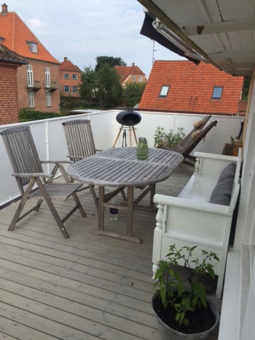 Roof top terrace with BBQ, recliners and bench.