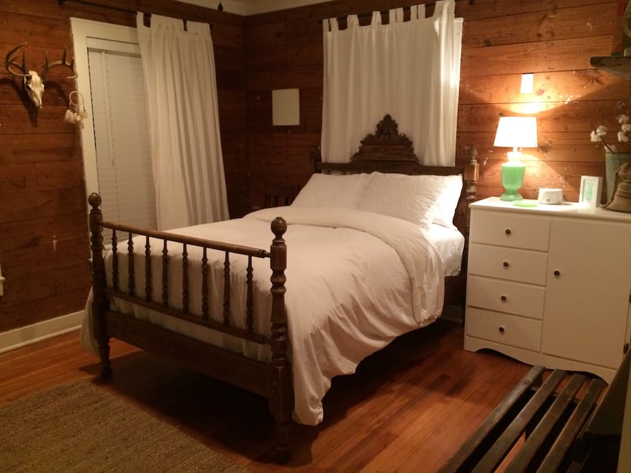 First guest room with antique wooden, full-size bed.
