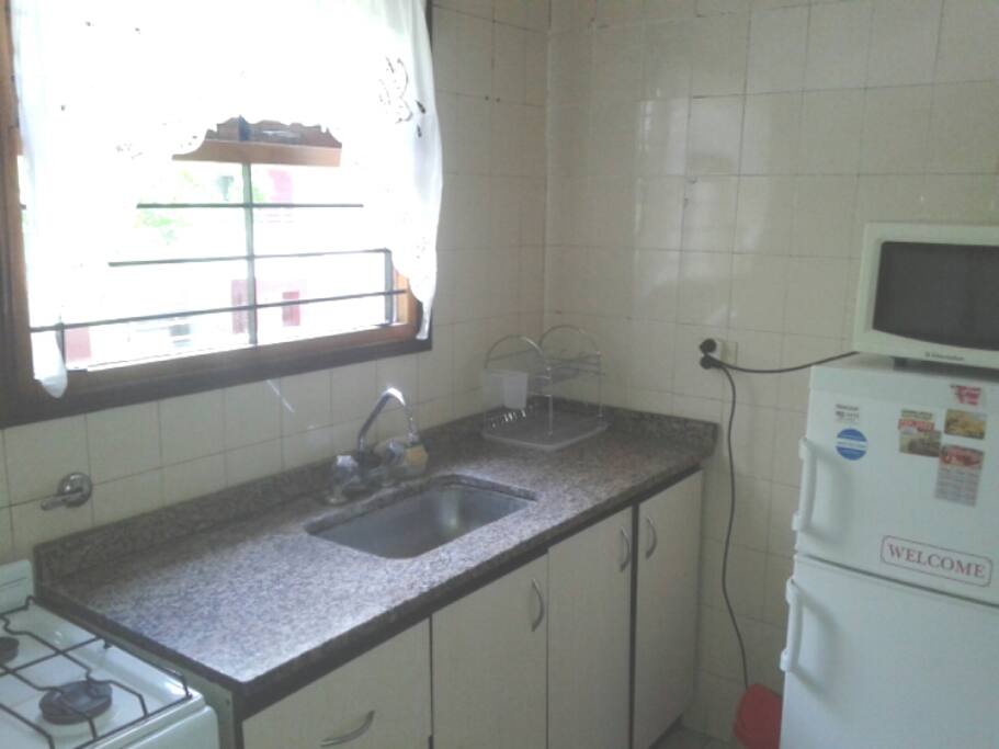 Cocina, con heladera, horno y microondas.