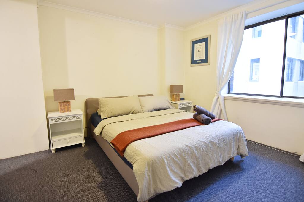 A bedroom with a queen sized bed with plush pillows.