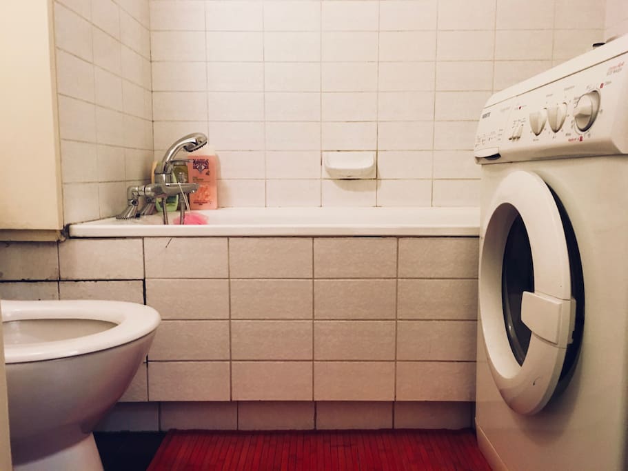 Salle de bain, grande baignoire, toilettes et lave linge.