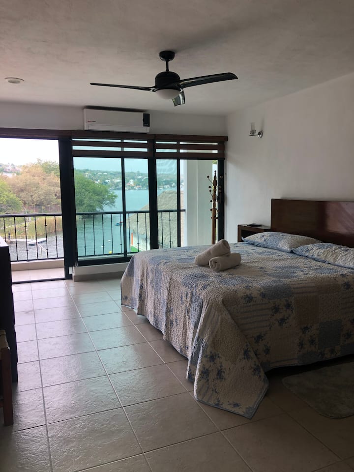 Spavaća soba 3, bračni krevet, klima-uređaj, stropni ventilator, televizor, s pogledom na balkon i jezero.