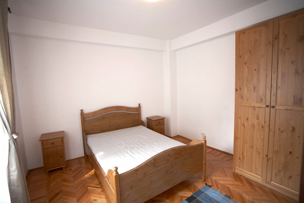 Bedroom One: It has a retro style, with solid wood furniture complementing the hardwood floor.