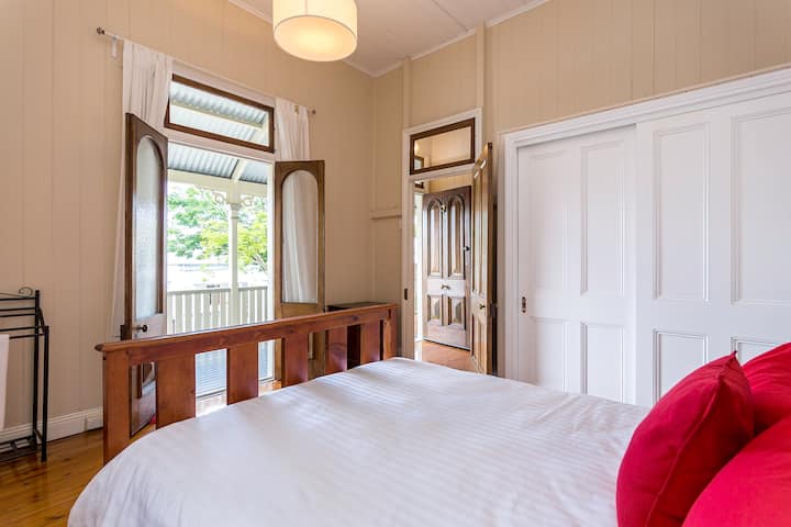 เตียงควีนไซส์พร้อมประตูฝรั่งเศสที่เปิดออกไปยังระเบียงด้านหน้า