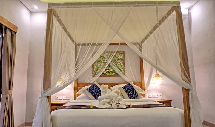 Შეაბიჯეთ კულტურული მომხიბვლელობისა და ელეგანტურობის სფეროში ჩვენი ოთახებით, რომელთაგან თითოეული კარგად მოფიქრებული ბალიანური დეკორაციებითაა მორთული. Ინტერიერში წარმოდგენილია ტრადიციული ბალიანური ხელოვნების ნიმუშები, ჩუქურთმები და ძლიერი ქსოვილები, რაც ქმნის მშვიდ და მიმზიდველ ატმოსფეროს