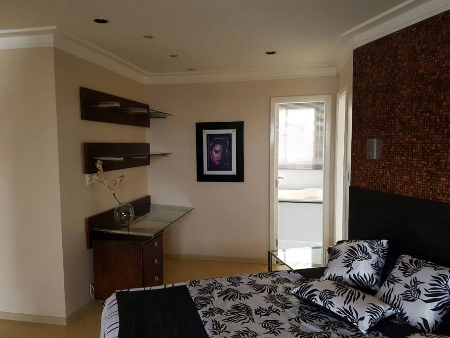 Quarto mobiliado e decorado, porta de acesso ao banheiro