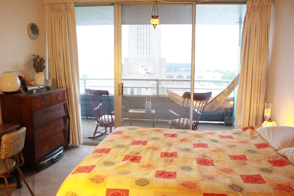View of the estate capitol from bedroom with sliding glass door to rocking chairs and hammock