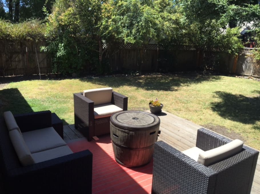 Backyard deck with lounge chairs, wine barrel fire table and gas BBQ. Perfect spot for post wine tasting evening drinks