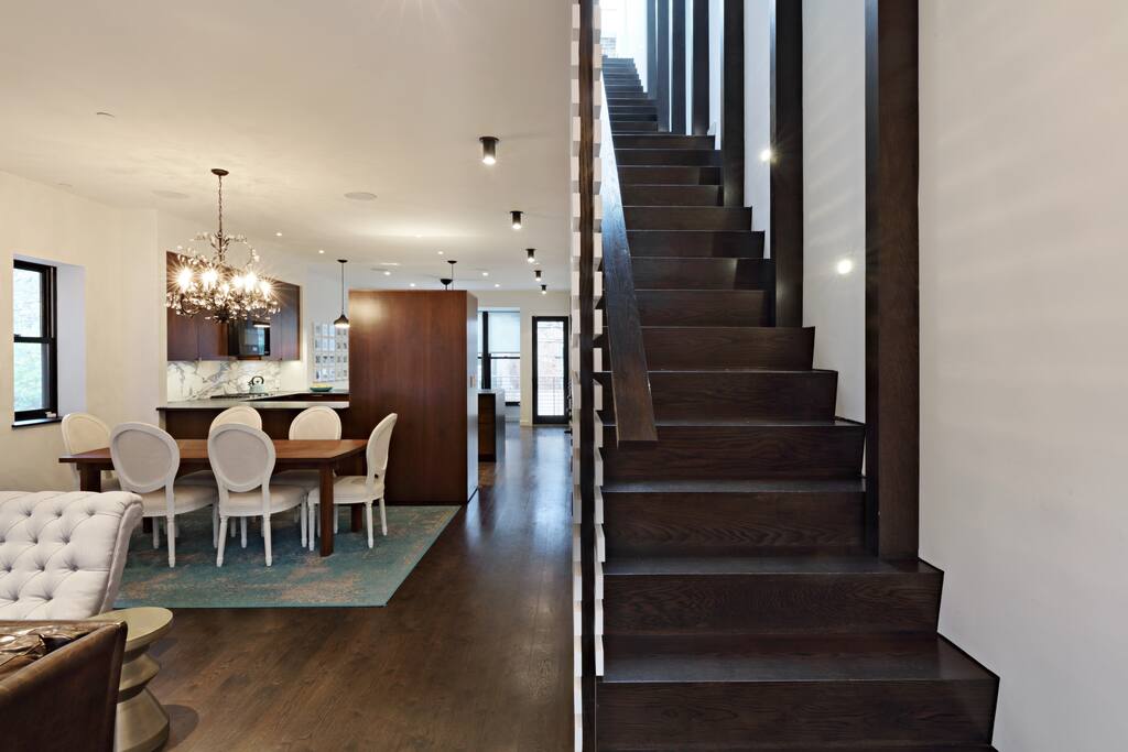 View from the front door entry of the parlor floor - living room, dining table for six, kitchen, and back sun room.