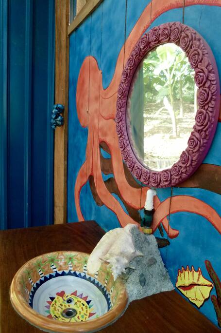 The colourful outdoor bathroom offers privacy & jungle views at the same time.