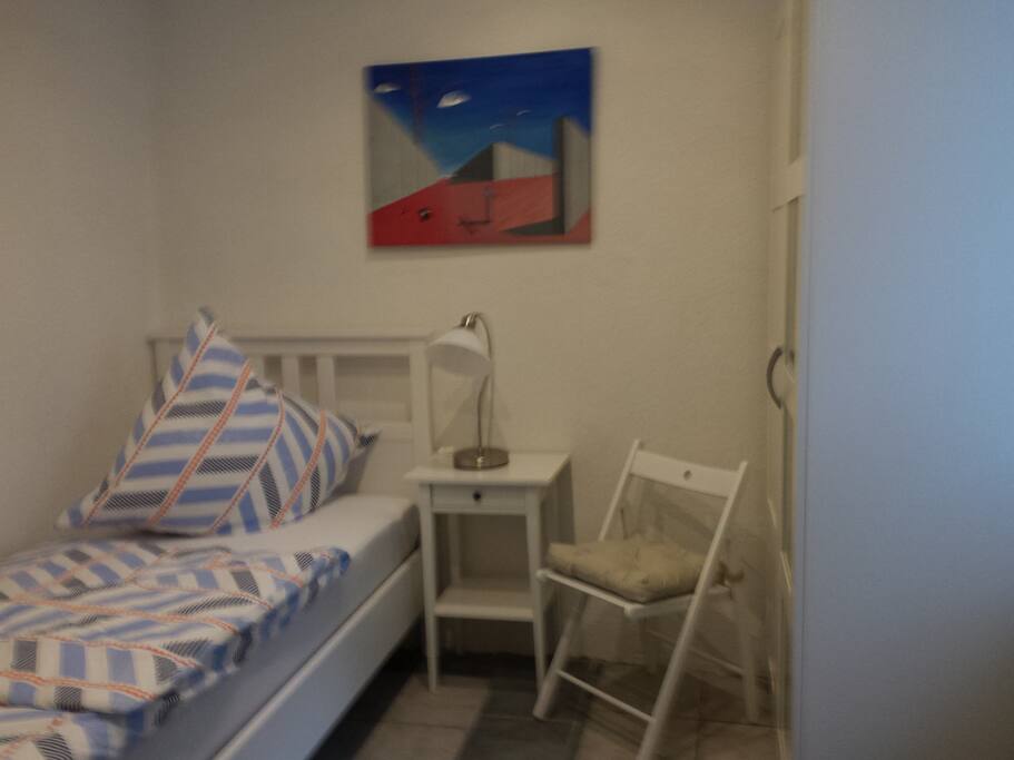 Schlafzimmer mit Einzelbett und Fernseher