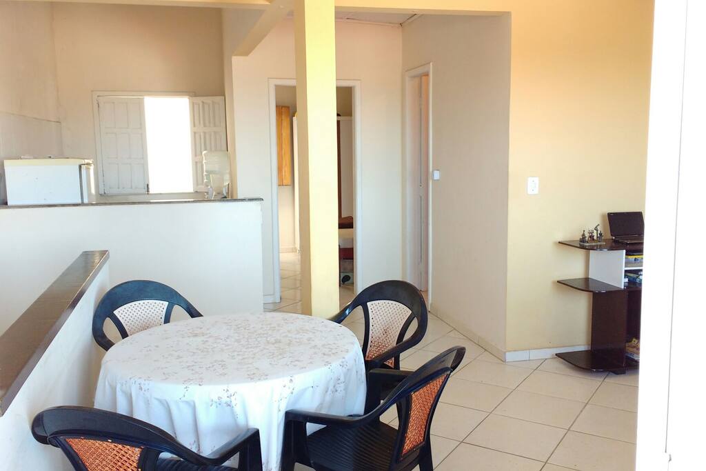 Sala com sofá, rack e mesa com 4 cadeiras