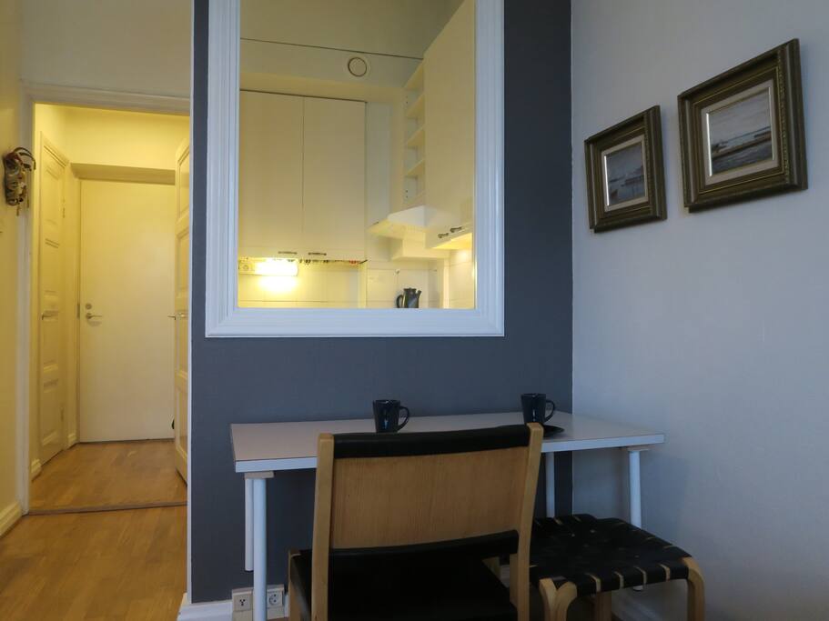 The working & eating table facing the internal window to the compact kitchen of this top floor one room + kitchen flat. Naturally seat by Artek, designed by the most famous Finnish architect and designer Alvar Aalto.