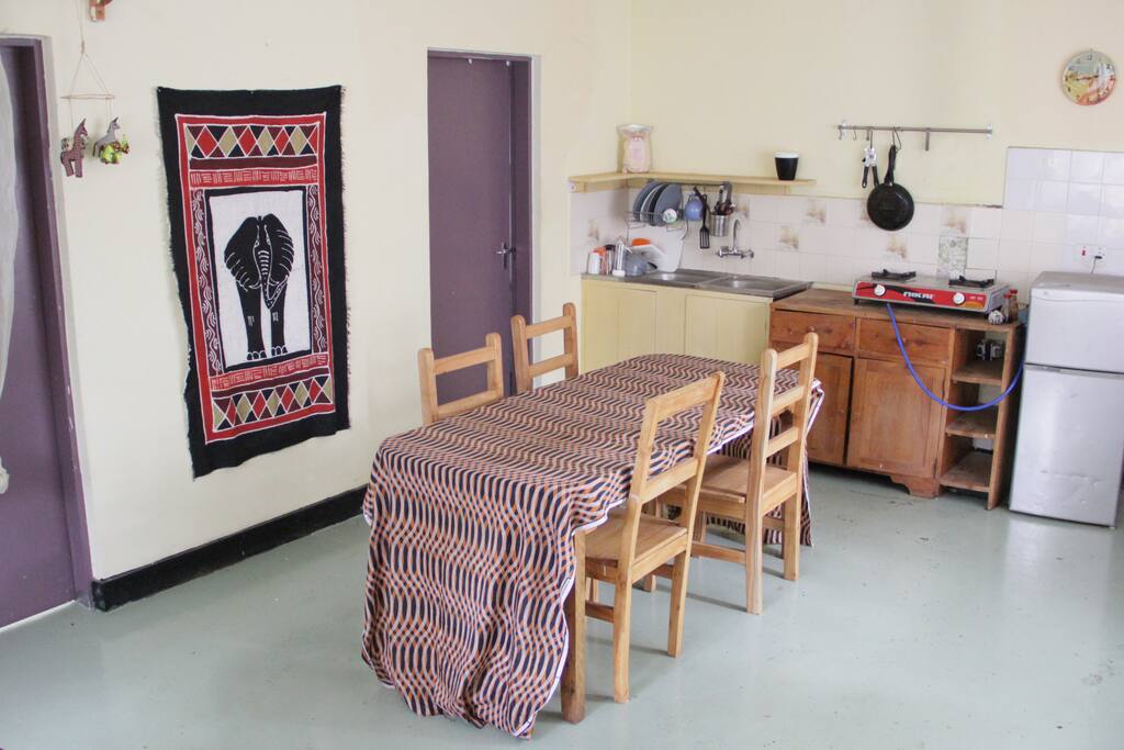 Kitchen with gas stove, fridge and dishes to be used.