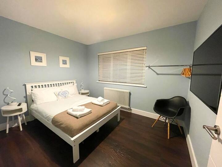 Bedroom 5 is located on the 1st floor, which has a 49" Smart TV. Bedroom 5 is next to the communal bathroom, which includes a shower, toilet, and wash basin.