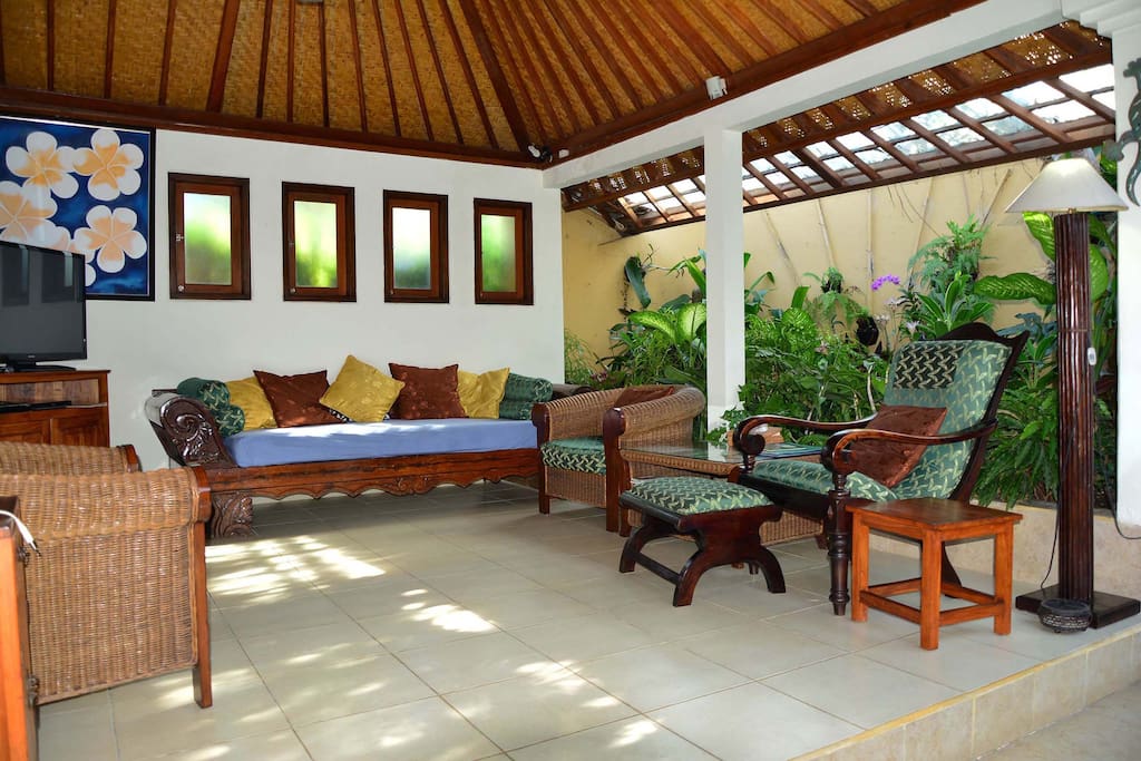 The living area is surrounded by tropical gardens.