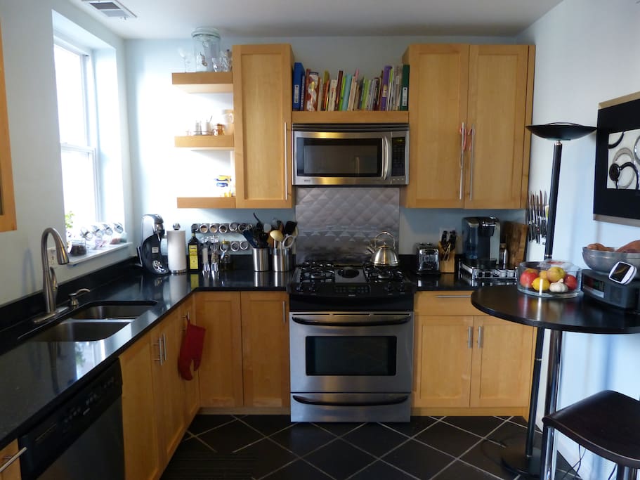 Gas stove, oven, microwave, toaster, coffee maker, dishwasher, and ample cabinet space.